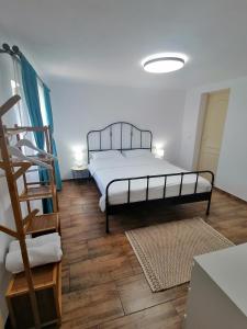 1 dormitorio con 1 cama y suelo de madera en Casa M.A.R.A, en Corbeni