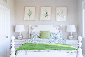 a bedroom with a white bed with green sheets and two lamps at Escape to Luxury Newport Coast Pelican Gated Home in Newport Beach