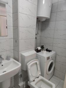 a white bathroom with a toilet and a sink at Apartmani Nina in Sarajevo