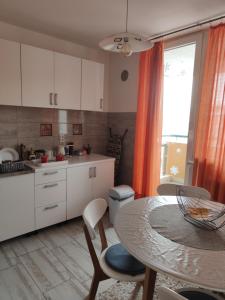 a kitchen with a table and a table and chairs at Apartmani Nina in Sarajevo
