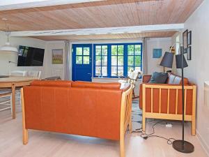 ØrstedにあるHoliday home Ørsted Vのリビングルーム(オレンジ色のソファ2台、テーブル付)