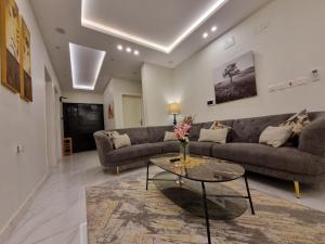 a living room with a couch and a table at شقة غرفتين وصالةفخمة ومتكاملة التجهيز قرب عسير مول in Abha