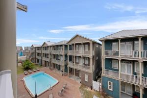 a view from a balcony of apartment buildings with a pool at Crescent Moon Palace - A Luxury Home with Pool, Parking, Just steps to the Beach in Panama City Beach