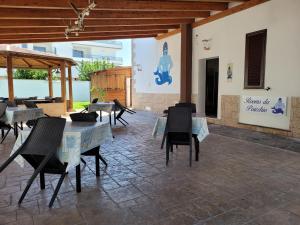 eine Terrasse mit Tischen und Stühlen in einem Gebäude in der Unterkunft Rooms da Pisicchio in Fiumicino