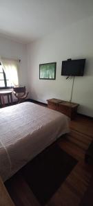 a bedroom with a bed and a flat screen tv at Hotel Coconuco by Destino Pacifico in Coconuco