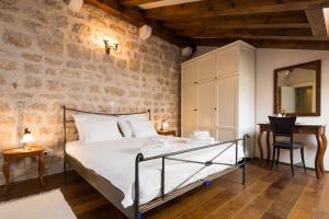 a bedroom with a bed and a stone wall at Holiday Home City Walls in Hvar