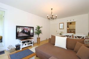 een woonkamer met een bank en een flatscreen-tv bij Sylt-to-hus-Alt-Westerland in Westerland