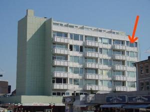 ein großes Gebäude mit einem orangenen Pfeil davor in der Unterkunft App. Rüter 57 in Westerland