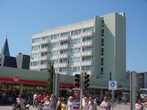 a crowd of people walking in front of a building at App-Kleinhubbert in Westerland (Sylt)