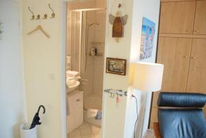 a bathroom with a shower and a toilet and a lamp at App-Kleinhubbert in Westerland (Sylt) +4 photos