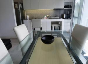 a kitchen with a glass table with a bowl on it at Espectacular Departamento Playa Grande/Golf Club Cochera Vista Moderno in Mar del Plata