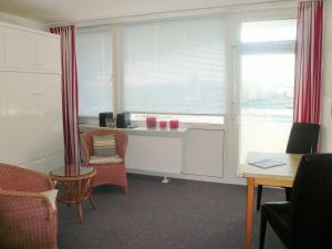 ein Wohnzimmer mit einem Tisch, Stühlen und einem Fenster in der Unterkunft Sievers 37 in Westerland