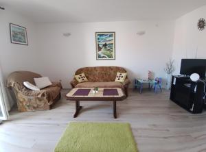 a living room with a couch and a coffee table at Apartments Vuleta in Pag