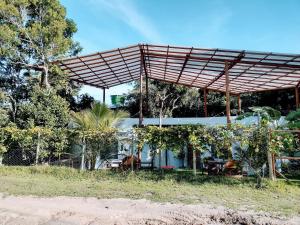 una casa con una pérgola encima en CASTEX BISTRÔ E CABANAS, en Arraial d'Ajuda
