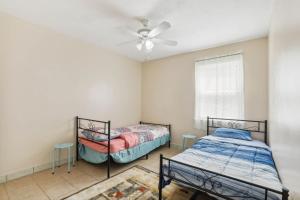 2 bedden in een kamer met een plafondventilator bij Snellville Getaway about 8 Mi to Stone Mountain Park! in Snellville