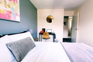 1 dormitorio con cama blanca y escritorio en Modern 2 bed House, free parking, central location, en Bristol