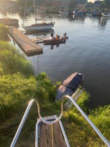 a boat is parked next to a dock on a body of water at Pāvilostas_laivas in Pāvilosta +10 photos