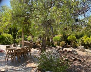 a table and chairs under a tree in a garden at Chalet - Casa móvil Pinos - 3 beds, pool, private garden in Alhaurín de la Torre