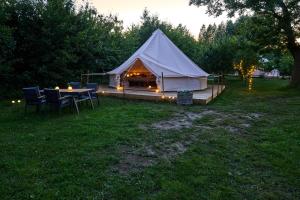 a tent with a table and chairs in a field at Hesselgaard Glamping in Dalby