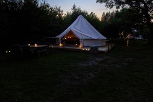 Dalby的住宿－Hesselgaard Glamping，夜晚在田野里带灯的帐篷