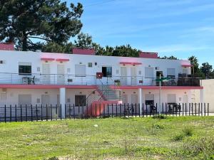 a large white building with a fence in front of it at Nice Resort Studio Holidays Family in Palmela in Quinta do Anjo