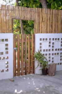 a wooden fence with a gate and a potted plant at Casa Makech 2 in Valladolid
