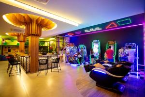 Pousada Arte da Natureza في بونيتو: غرفة بها بار والناس الذين يلعبون ألعاب الفيديو