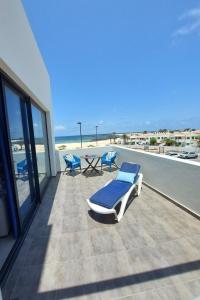 a balcony with chairs and a table and the beach at Casa Iris El Cotillo in Cotillo