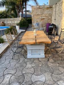 een houten tafel en stoelen op een patio bij Apulian Way in Torre Pelosa