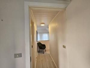 a hallway with a black chair in a room at VOT Vacation Homes-Akurhús in Gardur
