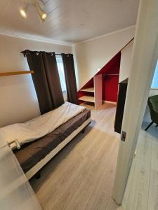 una camera con un letto in una stanza con scale di Akurhús a Gardur