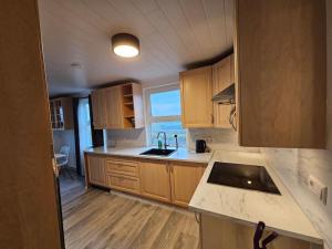 uma cozinha com armários de madeira e uma bancada em VOT Vacation Homes-Akurhús em Gardur