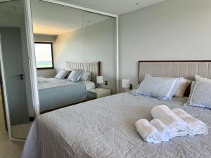 a bedroom with two beds and a large mirror at Aconchegante FLAT 807 in Vila Velha