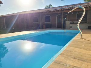 una piscina frente a una casa en Charmosa chácara do Broa! en Itirapina