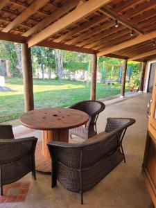 Une table et des chaises en bois sont disponibles sur la terrasse. dans l'établissement Charmosa chácara do Broa!, à Itirapina