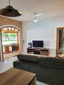 ein Wohnzimmer mit einem Sofa und einem TV in der Unterkunft Charmosa chácara do Broa! in Itirapina