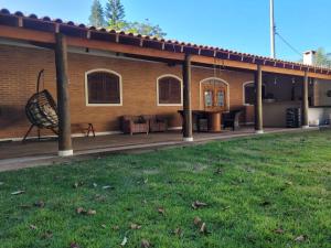 ein Haus mit einer großen Terrasse mit einem Hof in der Unterkunft Charmosa chácara do Broa! in Itirapina