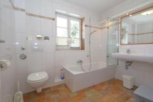 een badkamer met een toilet, een bad en een wastafel bij Landhaus-Friedrichshain-Theodor-Storm in Westerland