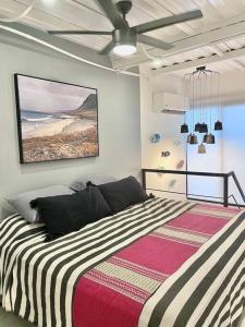 a bedroom with a large bed with a striped blanket at Deluxe Loft with TOP amenities in Cabo San Lucas
