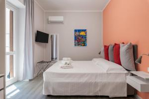 a bedroom with a large white bed with red pillows at Le Porte del Kassaro - Palermo Centro Storico Design Apartments & Balcony in Palermo