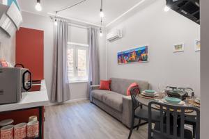 a living room with a couch and a table at Le Porte del Kassaro - Palermo Centro Storico Design Apartments & Balcony in Palermo
