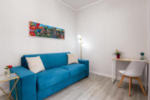 a blue couch in a living room with a table at Le Porte del Kassaro - Palermo Centro Storico Design Apartments & Balcony in Palermo