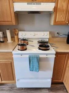 a white stove top oven with pots and pans on it at Modern and chic home with fine furnishing in Springfield