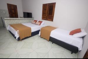 duas camas sentadas num quarto com em Canoa Hospedagem em Barra Grande