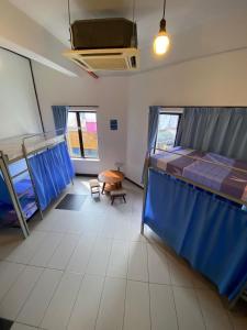 a room with two beds and a table in it at Marina Hostel in Ipoh