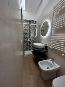 Baño blanco con lavabo y espejo en Il Pilone, en Barletta