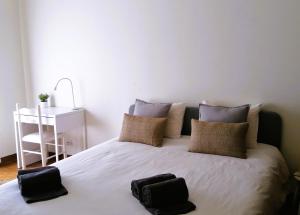 a bedroom with a bed with two bags on it at Nalu House Baleal - by the beach in Baleal