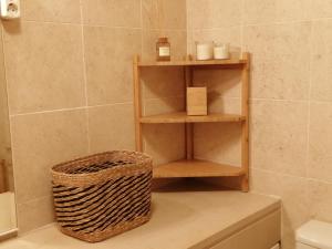 a bathroom with wooden shelves and a basket at Nalu House Baleal - by the beach in Baleal +17 photos