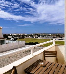 a table and chairs on a balcony with a view of a field at Nalu House Baleal - by the beach in Baleal