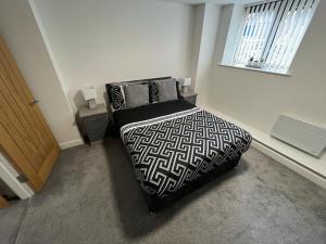 a bedroom with a black and white bed and a window at Modern Loft Apartment in Rotherham